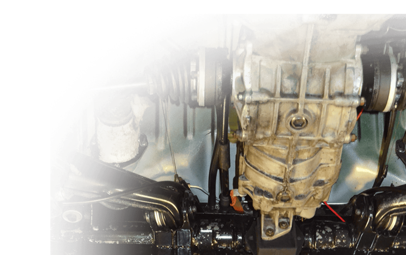 Unter einem Fahrzeug sind das Getriebe, die Aufhängungskomponenten und die Achsgelenke zu sehen